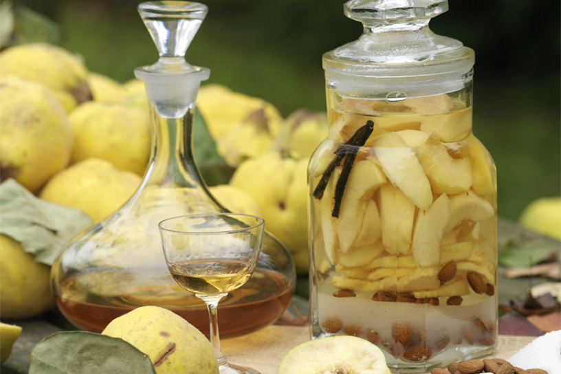 Kweeperen en likeur in glazen fles